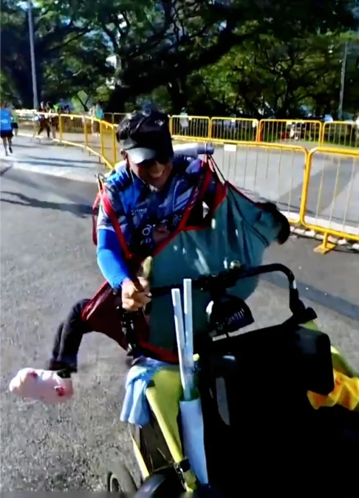 The emotional moment Wira Rabu carries his daughter Dihan in a sling across the finish line of the 21.1km half marathon.