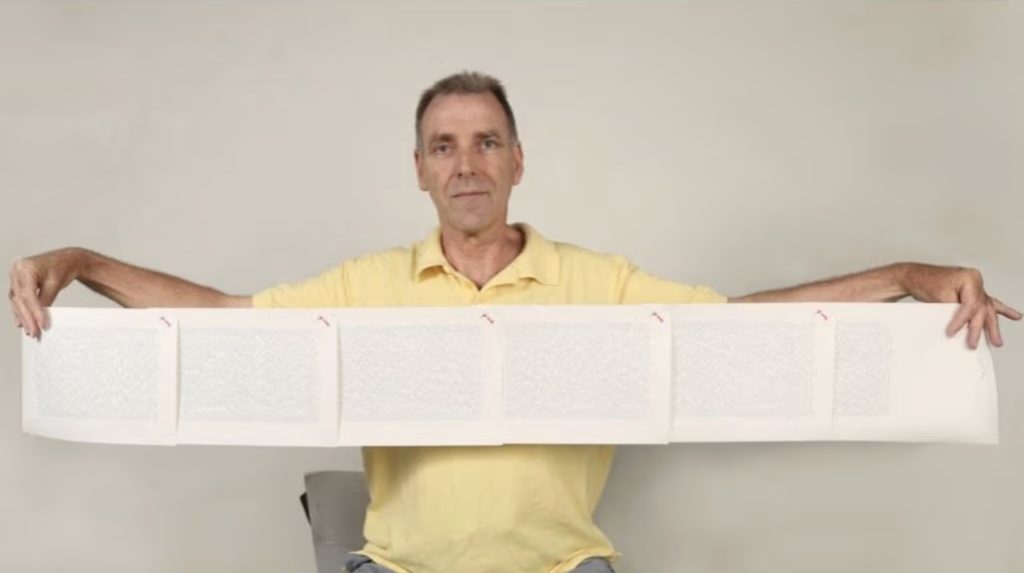 "Laurence Watkins holding his 1991 New Zealand passport with extra pages for the world’s longest personal name"