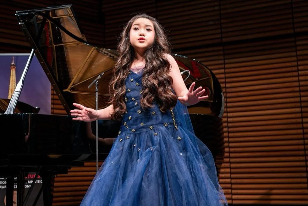 Young Malaysian talent Taylor Louise posing with her trophies after winning in France