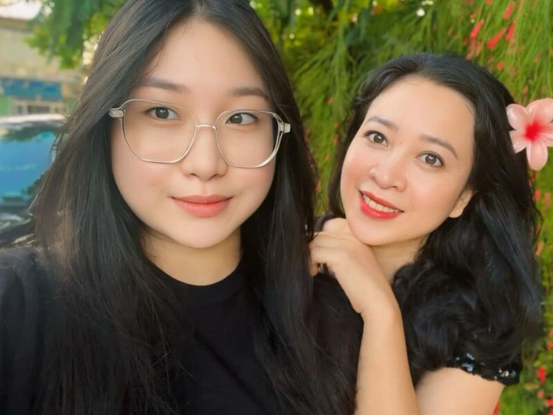 Trọng Tấn and Thanh Hoa's 19-year-old daughter posing confidently with large decorative pottery at an entertainment venue"