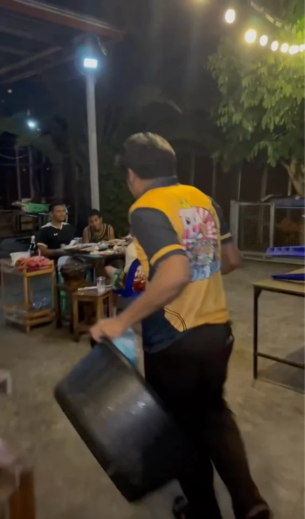 Restaurant employee bringing a dishwashing basin and soap to a table of customers