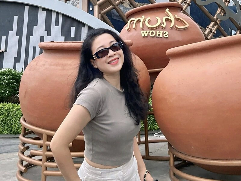 "Thanh Hoa, wife of Vietnamese singer Trọng Tấn, taking a joyful selfie with her 19-year-old daughter outdoors"