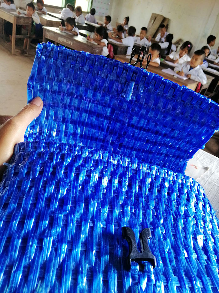 "Close-up of hand-woven blue raffia school backpack made by Cambodian farmer"