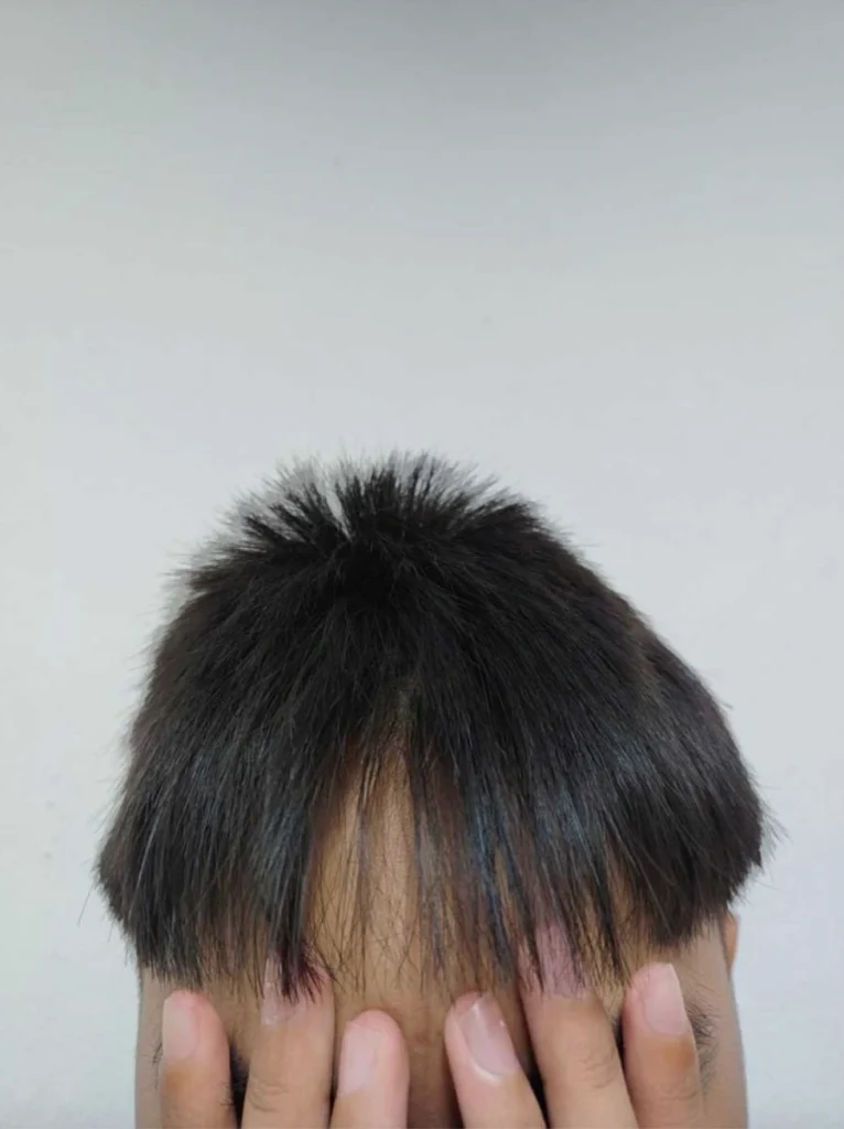 A young boy with an uneven, patchy haircut, which was the subject of the initial social media complaint by his mother