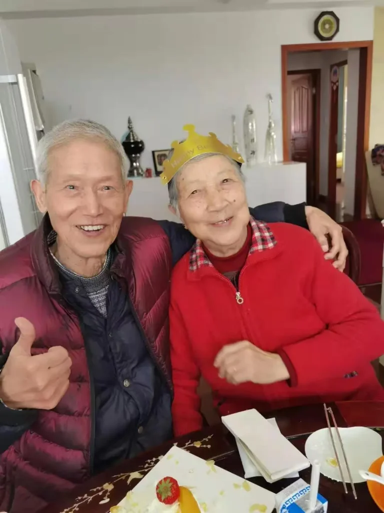 "Wang Huaibai (101) and Zhang Lanfeng (97) holding hands"