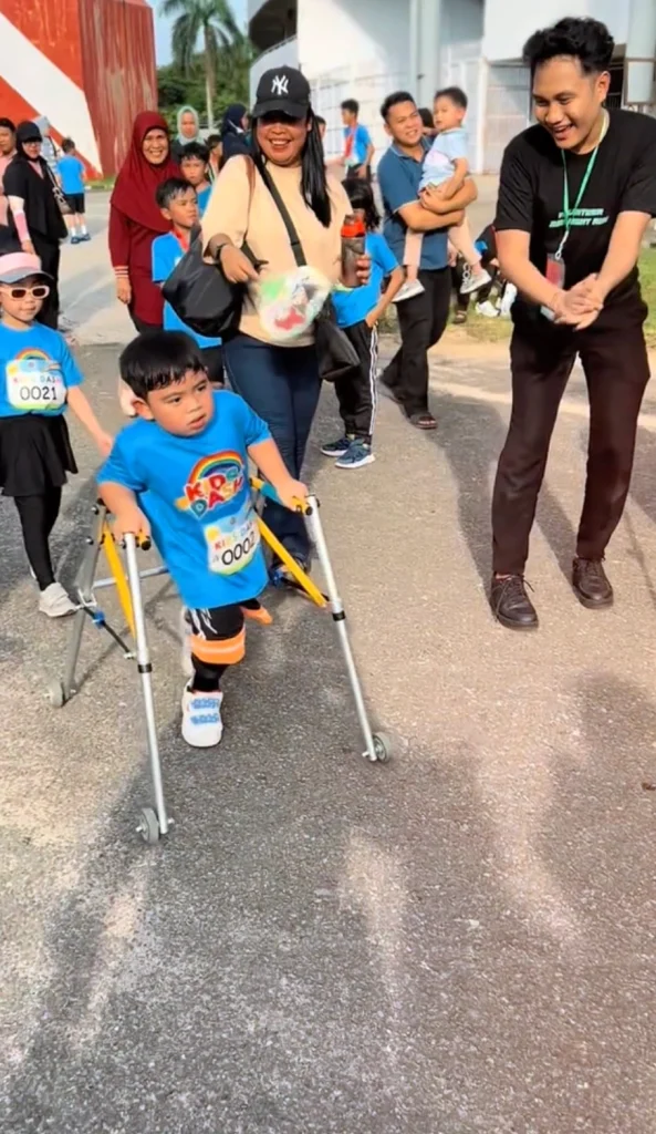 Zeeshan's determination shines through as he grips his walker on the race track