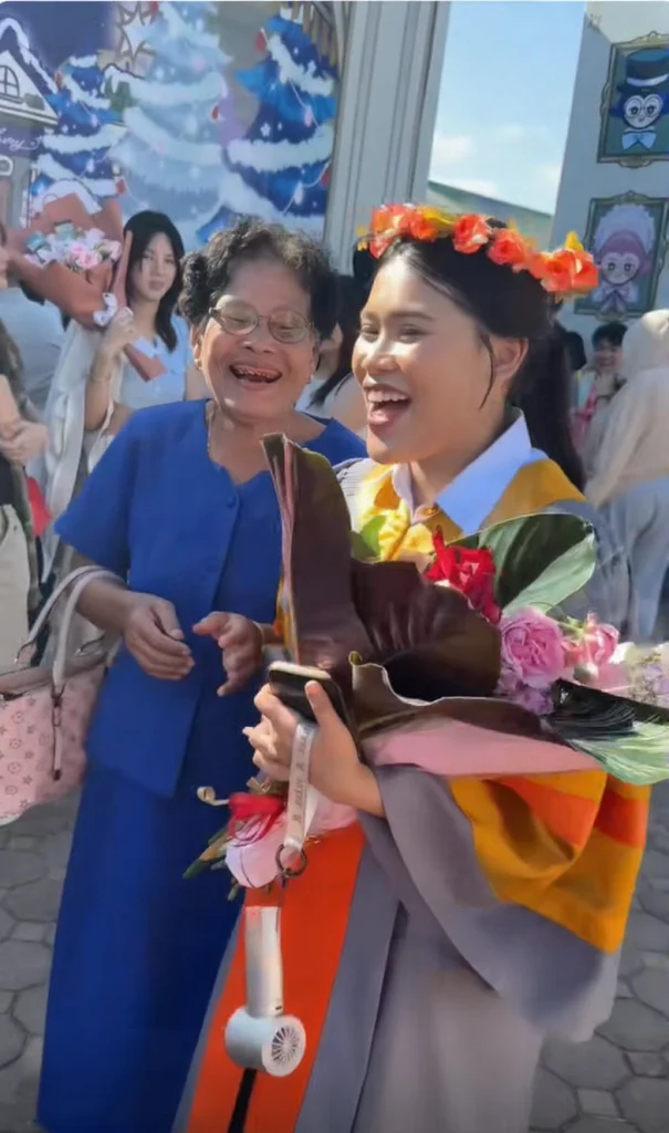 Elderly grandmother sitting on the floor arranging a handmade flower bouquet for her grandchild's graduation ceremony.